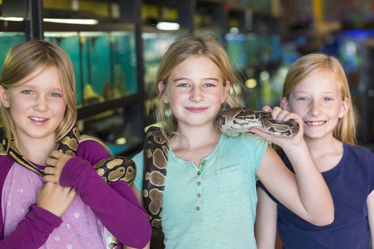 Girls holding snake in pet store