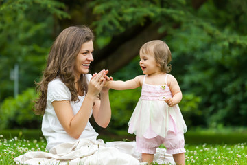 Mother and little daughter playing in the park