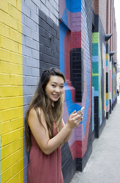 Asian woman using cell phone outdoors
