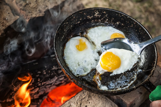 fire-roasted eggs in a frying pan and an shovel