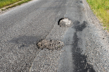 Große Schlaglöcher auf einer Landstraße Straßenschäden