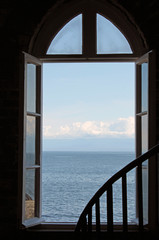 Looking Out an Open  Window to the Blue Ocean and Sky
