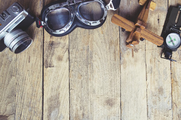 Vintage retro travel background. Retro camera, glasses, balsa wood model airplane and compass on...