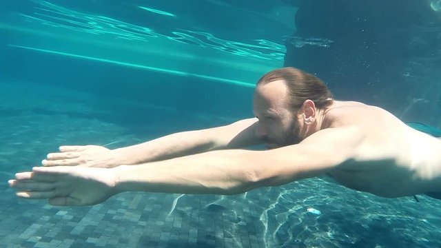 Man swimming, diving in swimming pool
