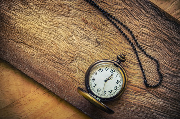 vintage pocket watch on wood board background