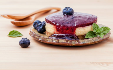 Blueberry cheesecake with fresh mint leaves on wooden background