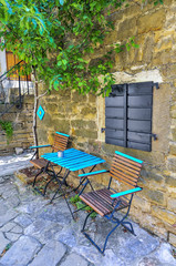 Turquoise table and chairs in front of old stone house