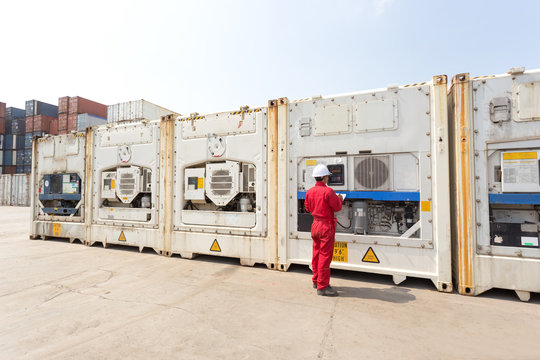 Engineer checking equipment in control system of reefer container box at yard