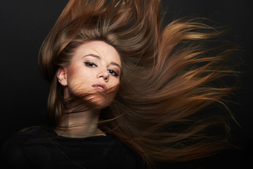 Fashion portrait of young beautiful woman with Flying healthy brown hair