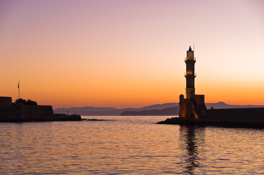 Scenic view of the entrance to Chania harbor with lighthouse at sunset, Crete, Greece