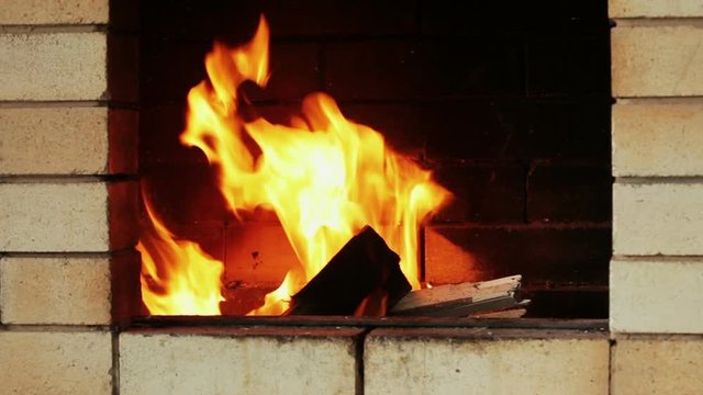 Rural life. Burning chop wood in the stone fire-place from fire-bricks.