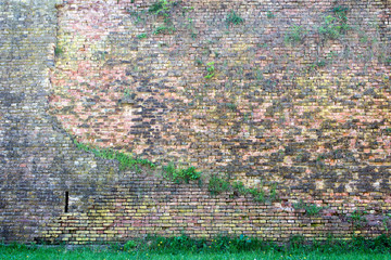 old red-orange brick wall and a lawn 13