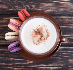 Cup of coffee and macaroon on the boards.