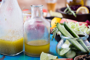 Vinaigrette and ingredients. Organic vegetables on rustic table