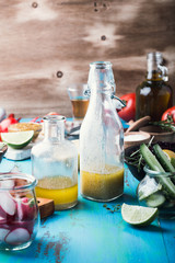 Vinaigrette and ingredients. Organic vegetables on rustic table