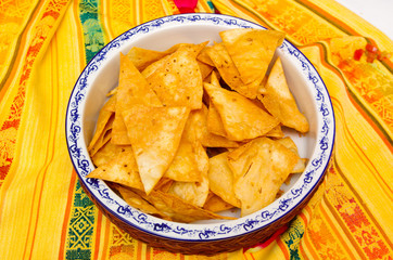 Bowl of crunchy delicous tortilla chips sitting on native american table cloth