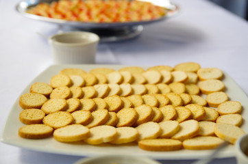 Thin crunchy toasted baguette slices stacked up on white plate