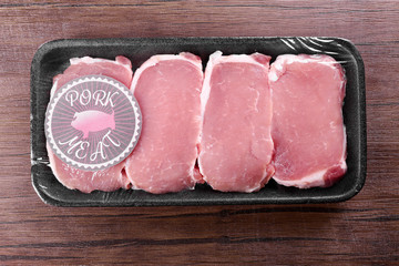 Packed pieces of pork meat on wooden background