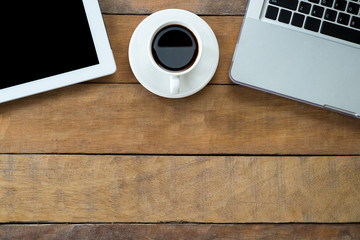 Office desk table with labtop, blank screen tablet and coffee cup ,.Top view with copy space