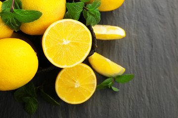 Fototapeta na wymiar Slices of fresh lemon with green leaves on table closeup
