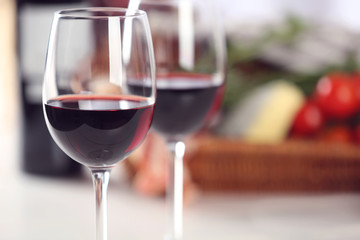 Glasses of red wine with food on table closeup