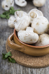 Raw mushrooms in a bowl on a table