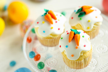 Cake stand with Easter cupcakes and eggs on wooden table