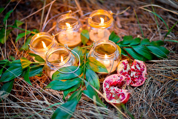 The lamps made of a jars with a candles  is  in the forest.