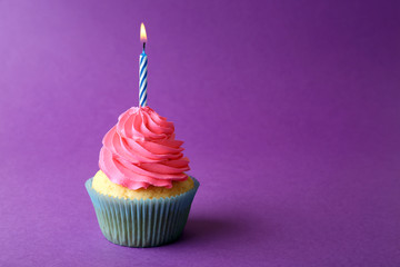 Birthday cupcake with candle on purple background