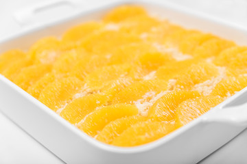 Pie with oranges in the baking dish  on a white table