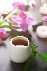 Beautiful spa set with massage oil and orchid on the table, close up