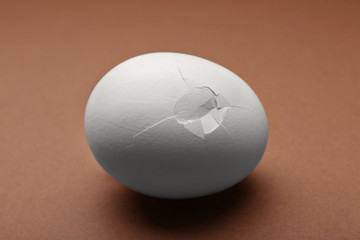 Cracked egg on brown background