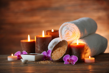 Spa composition with candles on brown background