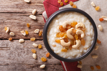 Tasty rice pudding with nuts and raisins close-up. horizontal top view
