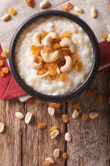 Tasty rice pudding with nuts and raisins close-up. Vertical top view
