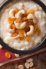 sweet rice pudding with nuts and raisins in a bowl close-up. Vertical top view

