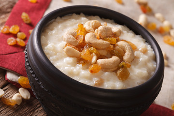 rice pudding with nuts and raisins in a bowl close-up. horizontal
