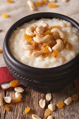 Indian cuisine: kheer rice pudding with nuts and raisins close-up. vertical
