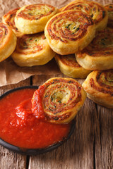 Fototapeta na wymiar sliced potato rolls with tomato sauce close up. vertical 