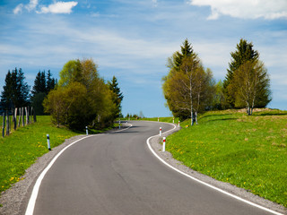 Fototapeta na wymiar Narrow rural asphalt road in the mountains