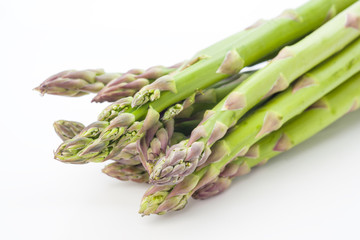 whole raw green asparagus on white