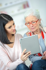 Helping old woman use a tablet computer