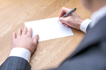 Obraz premium businessman writing on white paper on table