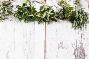 Bottle with herbs on wooden background. Mint, thyme, balm and other medicinal herbs