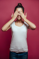 Smiling girl with brunette hair on red background.studio portrai