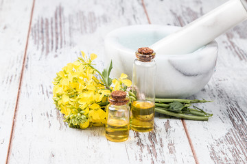 Rape oil and flower on wooden table 