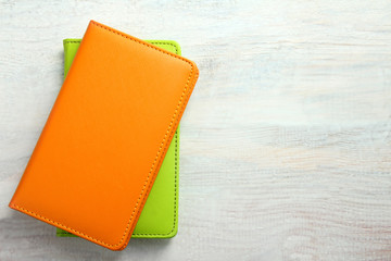 orange and green notebooks on a white wooden background