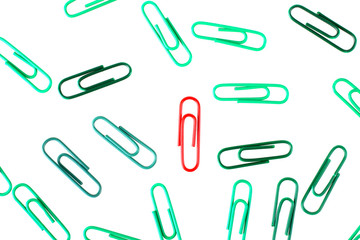 Odin red paper clip in a pile of green paper clips. The concept of individuality