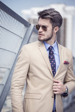 Handsome man in bright suit against the city