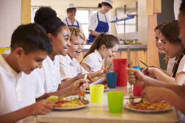 Primary school kids at a table in school cafeteria, close up - Powered by Adobe
